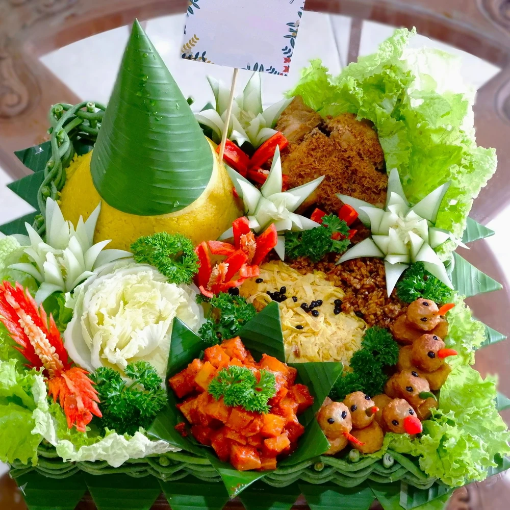 Tumpeng nasi kuning dengan lauk; foto stok
